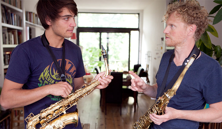 Foto van Jeroen met een leerlinge, beiden met saxofoon in de hand.